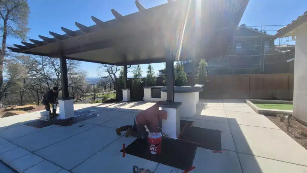Professional installer constructing a custom patio cover with tools and materials