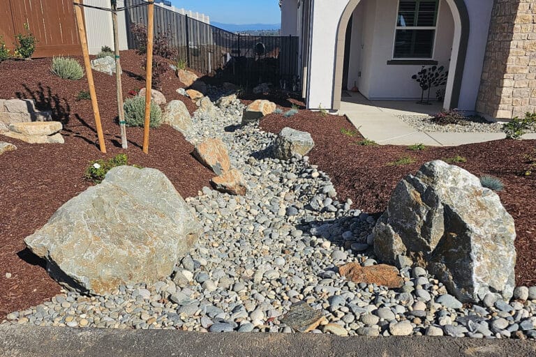 dry creek bed installation in front yard