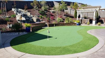 putting green in backyard next to a pergola